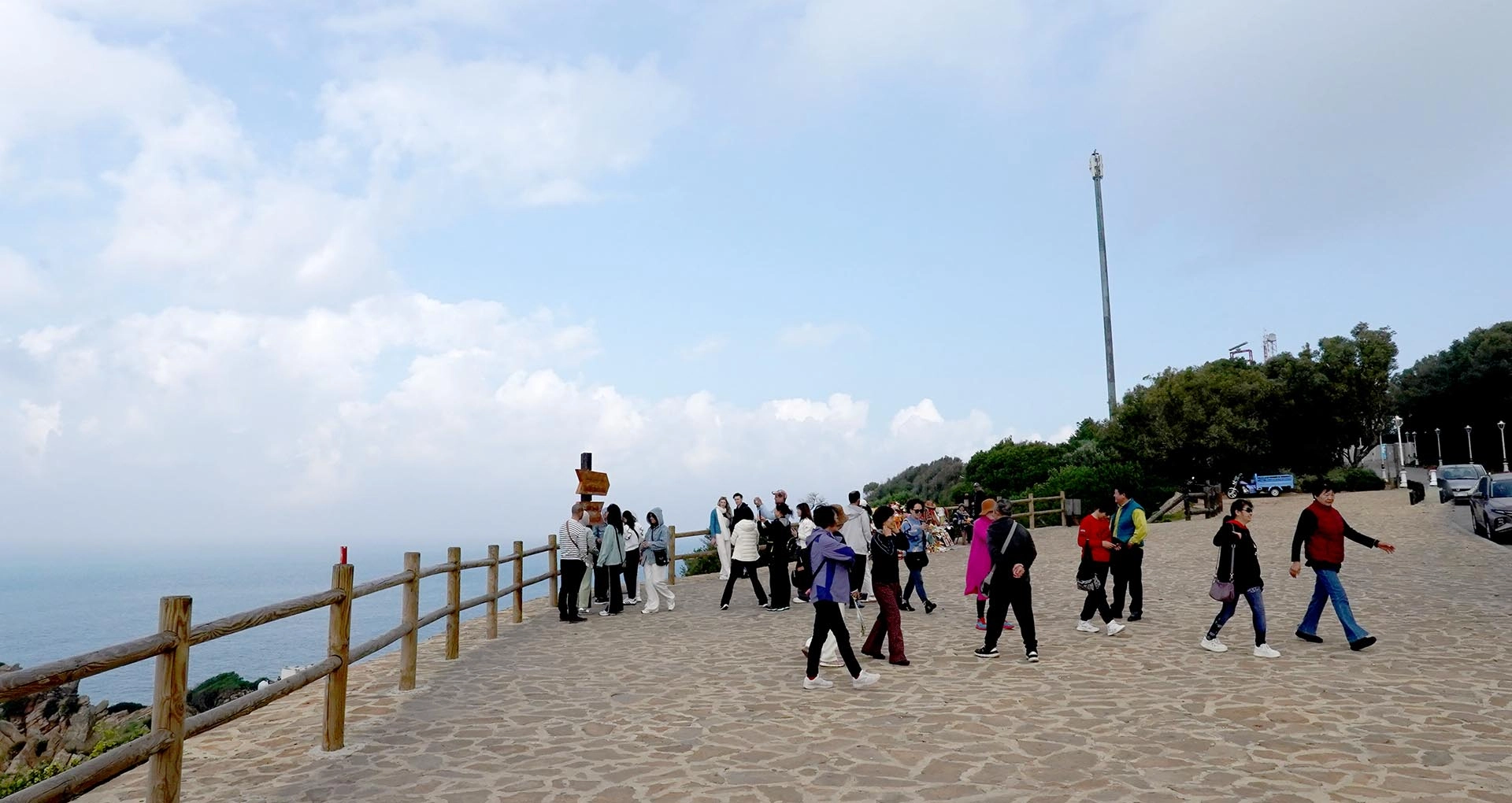 A group of Japanese doctors standing at the scenic viewpoint in Tangier, Morocco, where the Mediterranean Sea meets the Atlantic Ocean, enjoying the breathtaking view and cultural experience.
